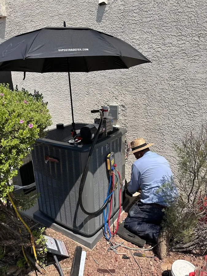 HVAC technician performing outdoor AC maintenance in Overland